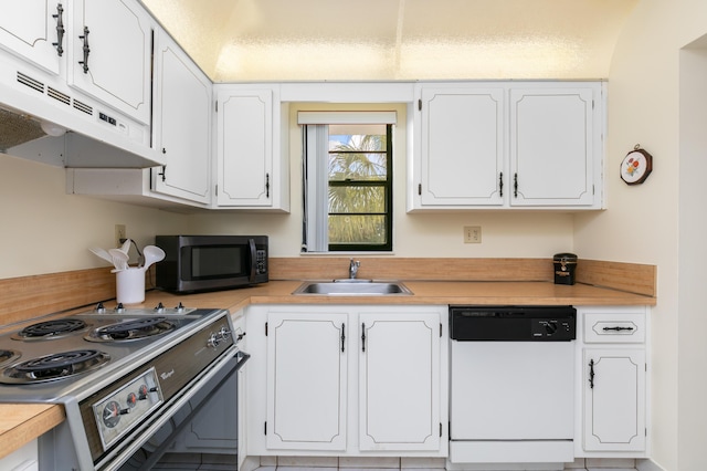 kitchen featuring white dishwasher, stainless steel range, white cabinetry, and sink