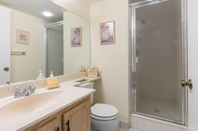 bathroom with walk in shower, vanity, tile patterned floors, and toilet