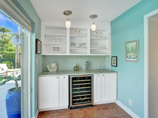 bar featuring white cabinets, light tile patterned floors, beverage cooler, and decorative light fixtures