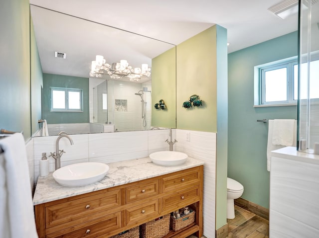 bathroom with a shower with door, vanity, hardwood / wood-style floors, and toilet