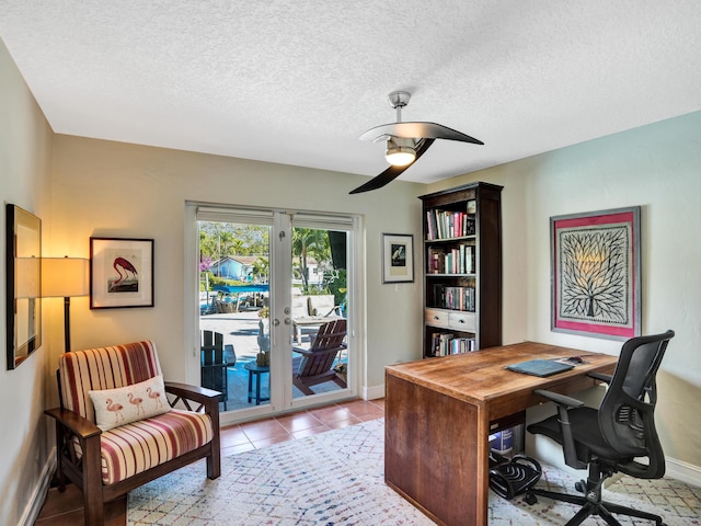 tiled office space featuring ceiling fan, french doors, and a textured ceiling