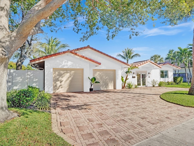 mediterranean / spanish-style home featuring a garage and french doors