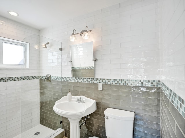 bathroom featuring tiled shower, tile walls, and toilet