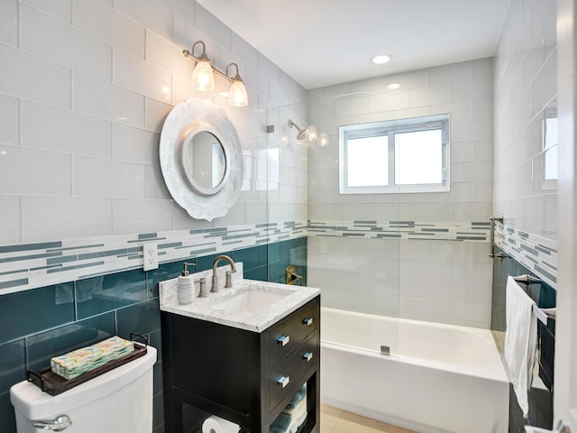 full bathroom with tile walls, tiled shower / bath combo, vanity, tasteful backsplash, and toilet