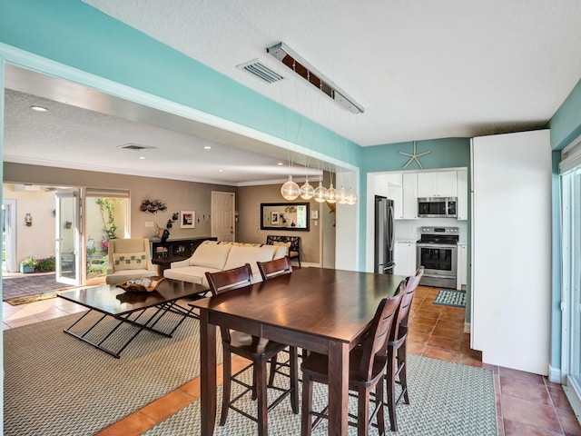 tiled dining room featuring a textured ceiling