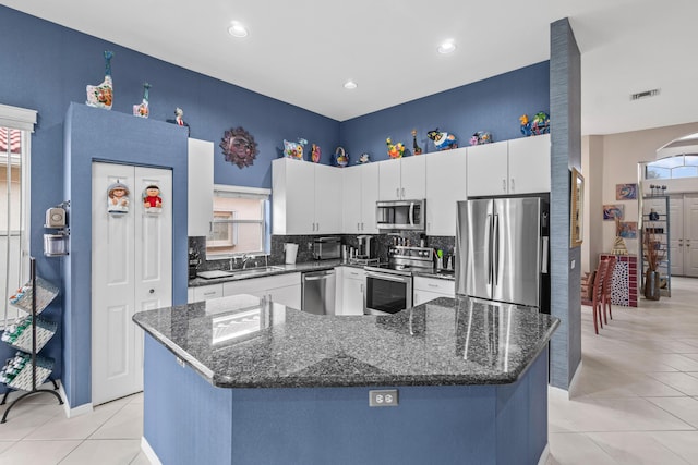 kitchen with sink, white cabinets, a center island, and appliances with stainless steel finishes