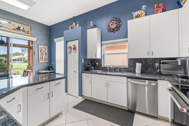 kitchen featuring sink, light tile patterned flooring, white cabinets, and stainless steel appliances