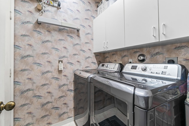 laundry room with washing machine and dryer and cabinets