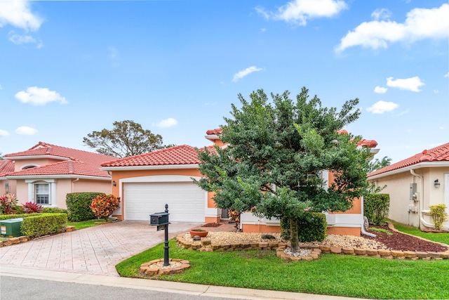 mediterranean / spanish-style home featuring a garage and a front lawn