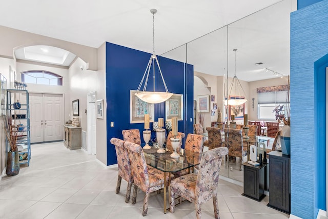 tiled dining area featuring a tray ceiling