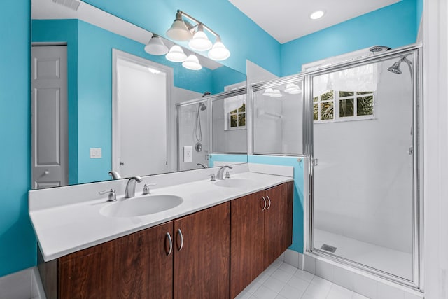 bathroom with a shower with shower door, vanity, and tile patterned flooring