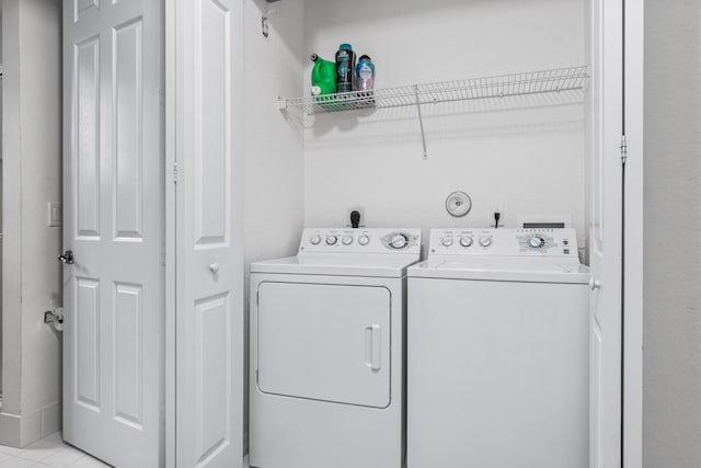 laundry area with light tile patterned floors and washing machine and clothes dryer