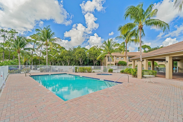 view of pool with a hot tub and a patio