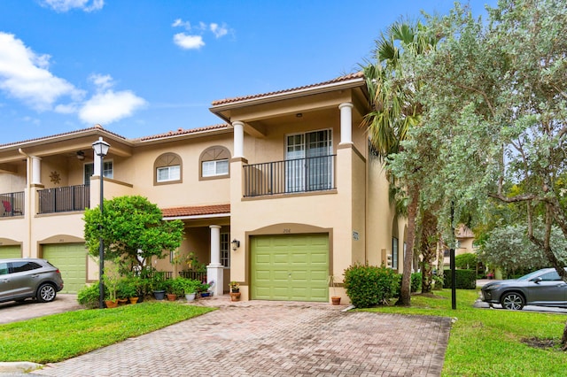 view of front of house with a front yard, a balcony, and a garage