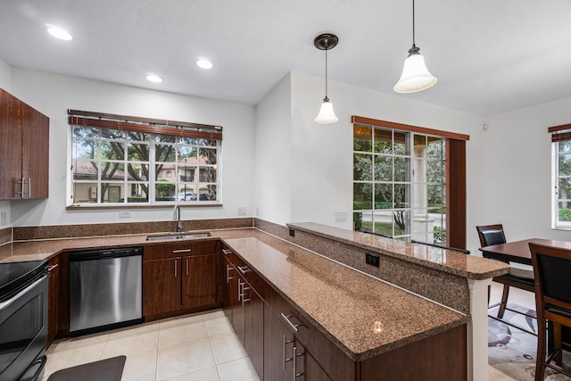 kitchen with dark stone countertops, pendant lighting, kitchen peninsula, sink, and stainless steel appliances