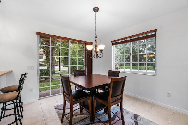 tiled dining room featuring a notable chandelier