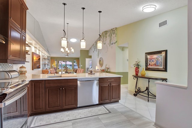 kitchen with decorative light fixtures, stainless steel appliances, sink, kitchen peninsula, and light tile patterned floors