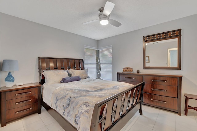 bedroom featuring a textured ceiling, light tile patterned floors, and ceiling fan