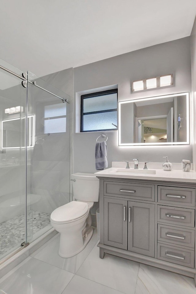 bathroom with vanity, toilet, and a shower with shower door