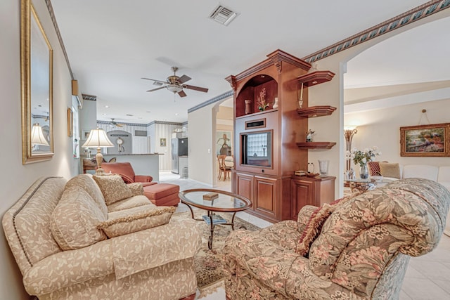 living room with ceiling fan, light tile patterned floors, and ornamental molding