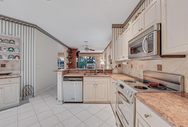 kitchen featuring kitchen peninsula, appliances with stainless steel finishes, decorative backsplash, light tile patterned flooring, and sink