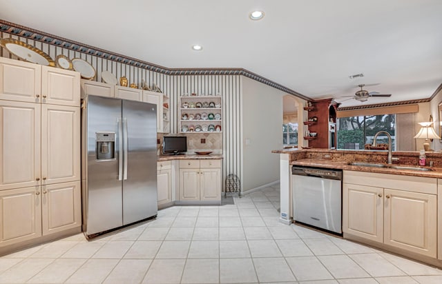 kitchen with appliances with stainless steel finishes, sink, ornamental molding, ceiling fan, and light tile patterned floors