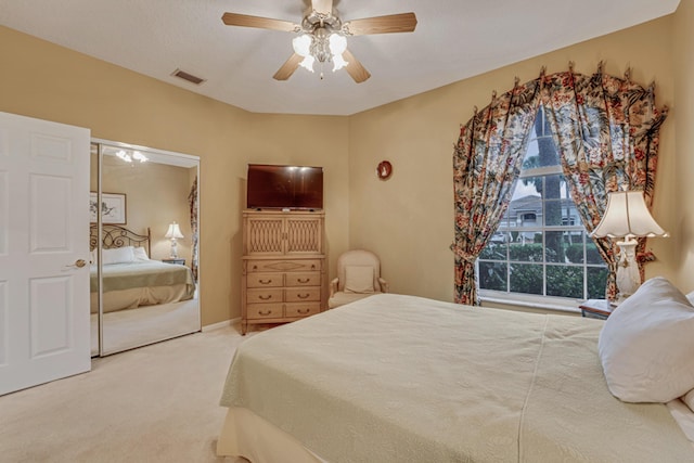 bedroom featuring ceiling fan, a closet, and carpet flooring