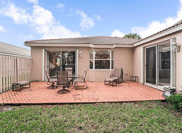 rear view of property featuring a lawn and a patio