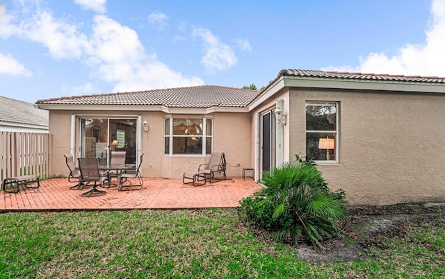 rear view of property featuring a yard and a patio