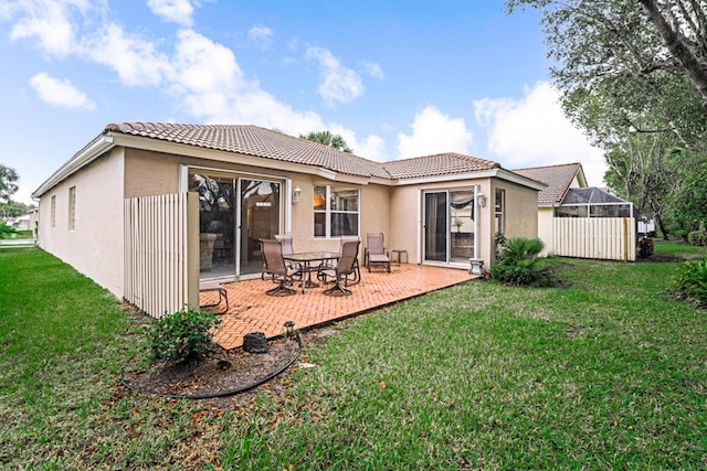 rear view of house featuring a lanai, a patio area, and a yard