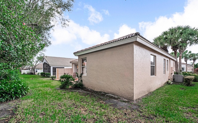 view of side of home featuring a yard and central air condition unit