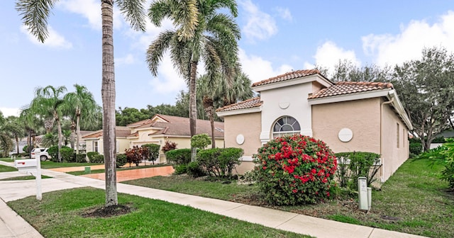 mediterranean / spanish-style house with a front yard