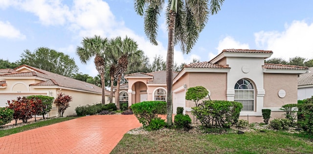 mediterranean / spanish house featuring a garage and a front yard