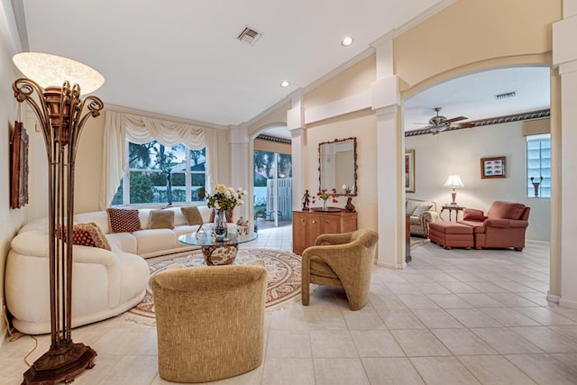 tiled living room with decorative columns, ornamental molding, and ceiling fan