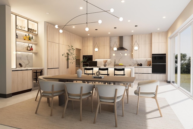 kitchen featuring wall chimney range hood, a center island, hanging light fixtures, and tasteful backsplash