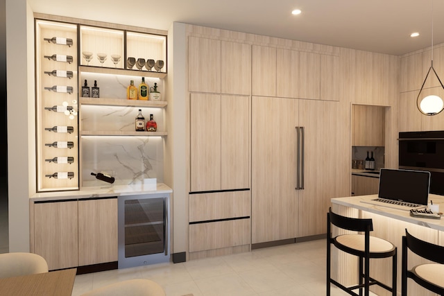 interior space with black oven, wine cooler, light brown cabinetry, light stone counters, and a breakfast bar