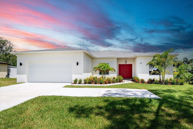 ranch-style house with a garage and a yard