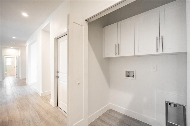 clothes washing area featuring cabinets, light hardwood / wood-style floors, and hookup for a washing machine