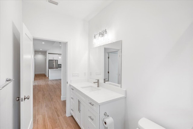 bathroom featuring toilet, hardwood / wood-style floors, and vanity