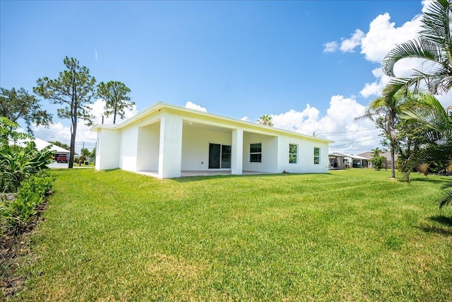 back of property featuring a patio area and a lawn