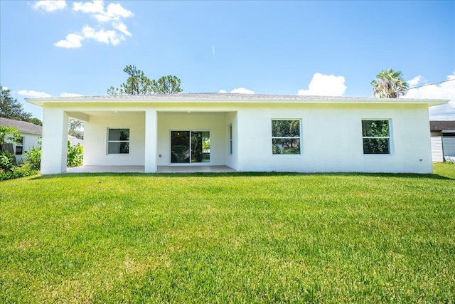 rear view of property with a lawn and a patio