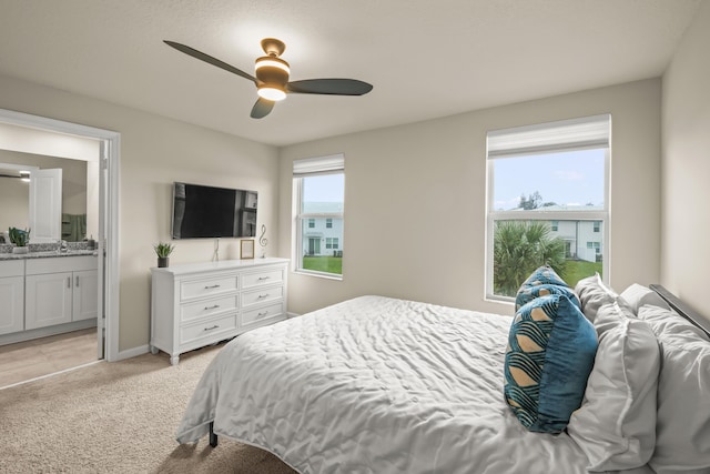 carpeted bedroom with ceiling fan and ensuite bathroom