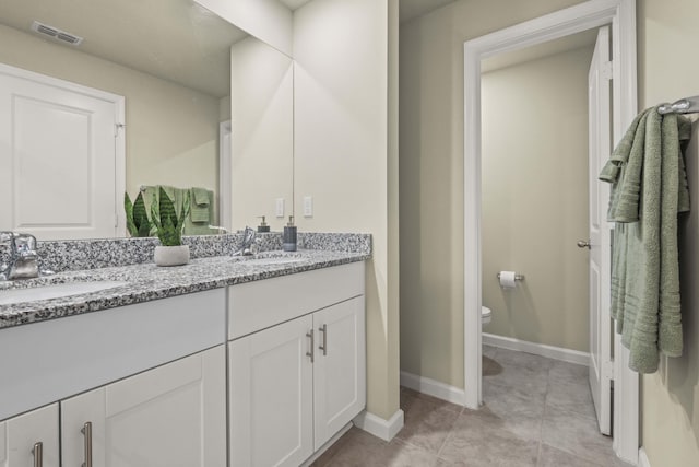 bathroom featuring toilet, vanity, and tile patterned flooring