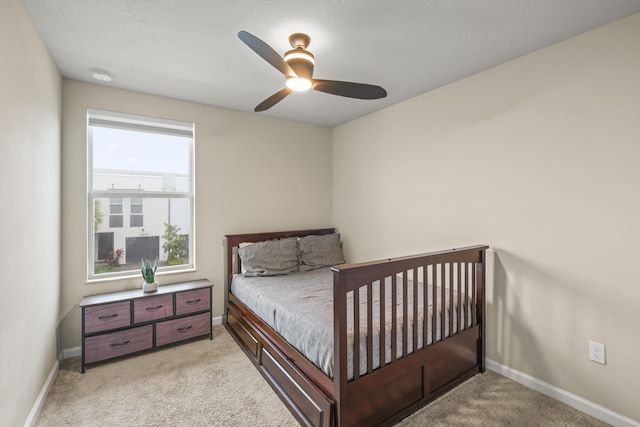 bedroom with ceiling fan and light carpet