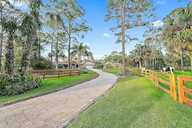 surrounding community featuring a lawn, fence, and a detached garage