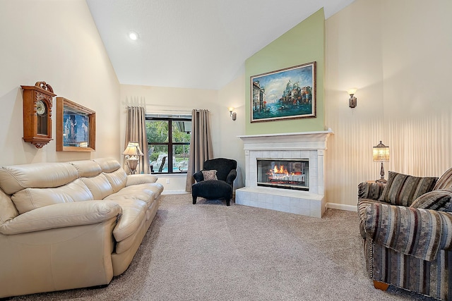 living room featuring vaulted ceiling, a tile fireplace, and carpet floors