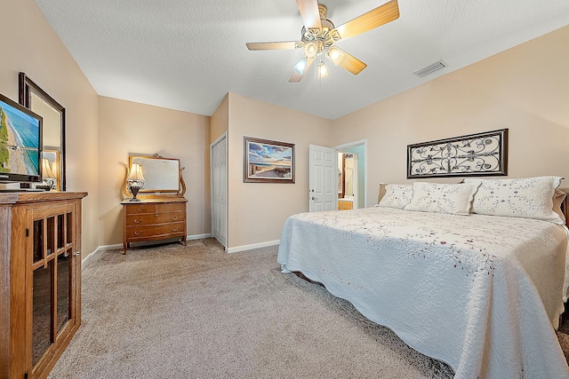 bedroom featuring a closet, ceiling fan, carpet flooring, and a textured ceiling