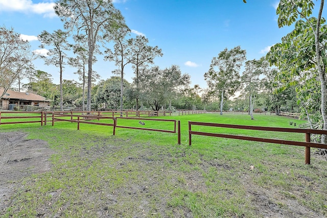 view of yard with fence and a rural view