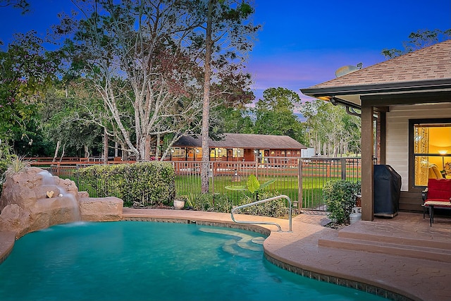 pool at dusk with a patio