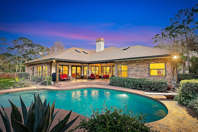 pool at dusk with a patio